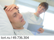 portrait of nurse feeling patients forehead. Стоковое фото, агентство Ingram Publishing / Фотобанк Лори