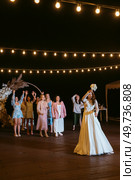 bride in a white dress throws a wedding bouquet to her unmarried girlfriends. Стоковое фото, агентство Ingram Publishing / Фотобанк Лори