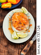 Fried salmon or trout steak with orange and lime sauce on wooden table.. Salmon or trout steak in orange marinade. Стоковое фото, агентство Ingram Publishing / Фотобанк Лори