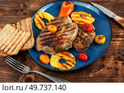 Grilled meat with pineapple rings, grilled steak and ananas on wooden table.. Pork steak with pineapple on plate. Стоковое фото, агентство Ingram Publishing / Фотобанк Лори