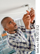 man is replacing a light bulb. Стоковое фото, агентство Ingram Publishing / Фотобанк Лори