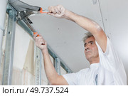 Builder mounting a metal frame. Стоковое фото, агентство Ingram Publishing / Фотобанк Лори