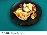 Roasted quarters chicken legs served with pineapple. Fried chicken meat on a black plate.. Chicken baked with pineapple. Стоковое фото, агентство Ingram Publishing / Фотобанк Лори