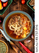 Tasty soup with meat on the table. Traditional Russian borscht on old rustic wooden table. Ukrainian cuisine.. Traditional soup borscht in bowl. Стоковое фото, агентство Ingram Publishing / Фотобанк Лори
