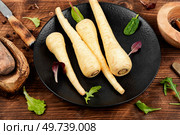 Raw parsnip roots or white root on the kitchen table. Root vegetables on a vintage wooden background.. Fresh parsnip roots. Стоковое фото, агентство Ingram Publishing / Фотобанк Лори