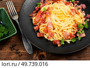 Pasta Carbonara with bacon and parmesan on a plate on old rustic wooden table. Italian pasta dish.. Italian traditional pasta carbonara. Стоковое фото, агентство Ingram Publishing / Фотобанк Лори
