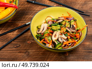 Salad of cucumber, onion and octopus. Healthy seafood salad in bowl on old rustic wooden table. Korean cuisine.. Healthy octopus salad. Стоковое фото, агентство Ingram Publishing / Фотобанк Лори