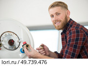 a happy man fixing a boiler. Стоковое фото, агентство Ingram Publishing / Фотобанк Лори