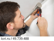 man using spirit level to check curtain rail. Стоковое фото, агентство Ingram Publishing / Фотобанк Лори