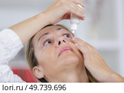 woman using eye lubricant to treat dry eye or allergy. Стоковое фото, агентство Ingram Publishing / Фотобанк Лори