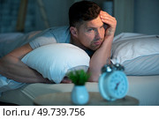 unhappy man on the bed. Стоковое фото, агентство Ingram Publishing / Фотобанк Лори