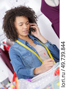 beautiful woman tailor answering phone call. Стоковое фото, агентство Ingram Publishing / Фотобанк Лори