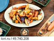 Healthy homemade roasted parsnip root, carrots and garlic on old rustic wooden table.. Baked parsnip root and carrots. Стоковое фото, агентство Ingram Publishing / Фотобанк Лори