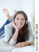 Girl with headphones layed on couch. Стоковое фото, агентство Ingram Publishing / Фотобанк Лори
