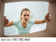young sad woman opening the biggest postal package. Стоковое фото, агентство Ingram Publishing / Фотобанк Лори