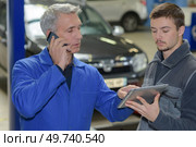 student with instructor repairing a car during apprenticeship. Стоковое фото, агентство Ingram Publishing / Фотобанк Лори