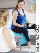 two pregnant women sat on aerobic balls. Стоковое фото, агентство Ingram Publishing / Фотобанк Лори
