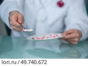 doctor offering spoonful of tablets. Стоковое фото, агентство Ingram Publishing / Фотобанк Лори