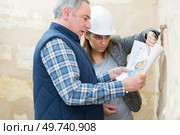 female architect holding blueprints with engineer. Стоковое фото, агентство Ingram Publishing / Фотобанк Лори