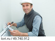 portrait of plumber fixing a radiator. Стоковое фото, агентство Ingram Publishing / Фотобанк Лори