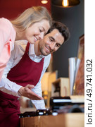 portrait of happy male seller talking to female customer. Стоковое фото, агентство Ingram Publishing / Фотобанк Лори