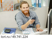 happy man in office holding a swatch. Стоковое фото, агентство Ingram Publishing / Фотобанк Лори