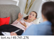 young woman lying on couch at doctors office. Стоковое фото, агентство Ingram Publishing / Фотобанк Лори