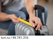 close-up of hands measuring luggage. Стоковое фото, агентство Ingram Publishing / Фотобанк Лори