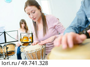 Music rehearsal, woman playing bongos. Стоковое фото, агентство Ingram Publishing / Фотобанк Лори