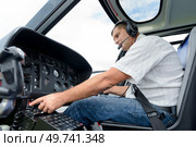 pilot adjusting controls in an aircraft. Стоковое фото, агентство Ingram Publishing / Фотобанк Лори