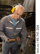 portrait of man forging by hand. Стоковое фото, агентство Ingram Publishing / Фотобанк Лори