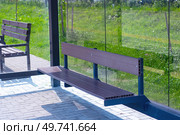 A beautifully crafted wooden bench sits conveniently in front of a glass wall. Стоковое фото, фотограф Аксенова Вера / Фотобанк Лори