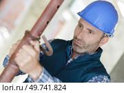 technician checking the state of metal pipes indoors. Стоковое фото, агентство Ingram Publishing / Фотобанк Лори