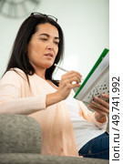 woman doing crosswords at home. Стоковое фото, агентство Ingram Publishing / Фотобанк Лори