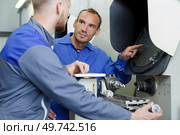 two happy positive mechanics working at workshop. Стоковое фото, агентство Ingram Publishing / Фотобанк Лори