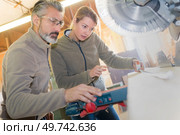 man and woman using a circular saw. Стоковое фото, агентство Ingram Publishing / Фотобанк Лори