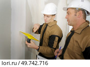 construction workers plastering and smoothing concrete wall wit. Стоковое фото, агентство Ingram Publishing / Фотобанк Лори