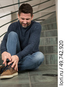 man has sustained a leg injury after falling down staircase. Стоковое фото, агентство Ingram Publishing / Фотобанк Лори