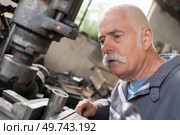 worker serves a cnc milling machine in mechanical engineering. Стоковое фото, агентство Ingram Publishing / Фотобанк Лори