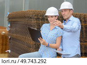 Man and woman stood by stack of reinforcing bars. Стоковое фото, агентство Ingram Publishing / Фотобанк Лори