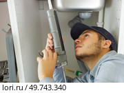 plumber sealing sink with silicone. Стоковое фото, агентство Ingram Publishing / Фотобанк Лори