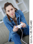 portrait of beautiful woman playing videogame at home. Стоковое фото, агентство Ingram Publishing / Фотобанк Лори