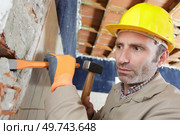 man hammers into the wall. Стоковое фото, агентство Ingram Publishing / Фотобанк Лори