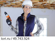 woman builder drilling on the wall. Стоковое фото, агентство Ingram Publishing / Фотобанк Лори