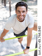 happy young man jumping on horizontal bar outdoors. Стоковое фото, агентство Ingram Publishing / Фотобанк Лори
