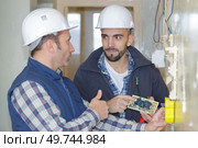 portrait of mentor instructing trainee electrician. Стоковое фото, агентство Ingram Publishing / Фотобанк Лори