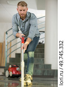 young man hoovering floor of business. Стоковое фото, агентство Ingram Publishing / Фотобанк Лори