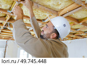 tradesman using screwdriver on ceiling timbers. Стоковое фото, агентство Ingram Publishing / Фотобанк Лори