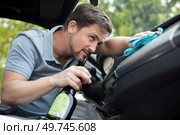 man vacuum cleaning his car interior. Стоковое фото, агентство Ingram Publishing / Фотобанк Лори