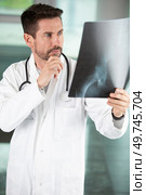 unsure doctor looking at xray. Стоковое фото, агентство Ingram Publishing / Фотобанк Лори